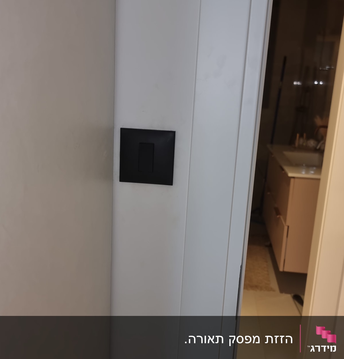 מתג חשמל שחור על קיר לבן